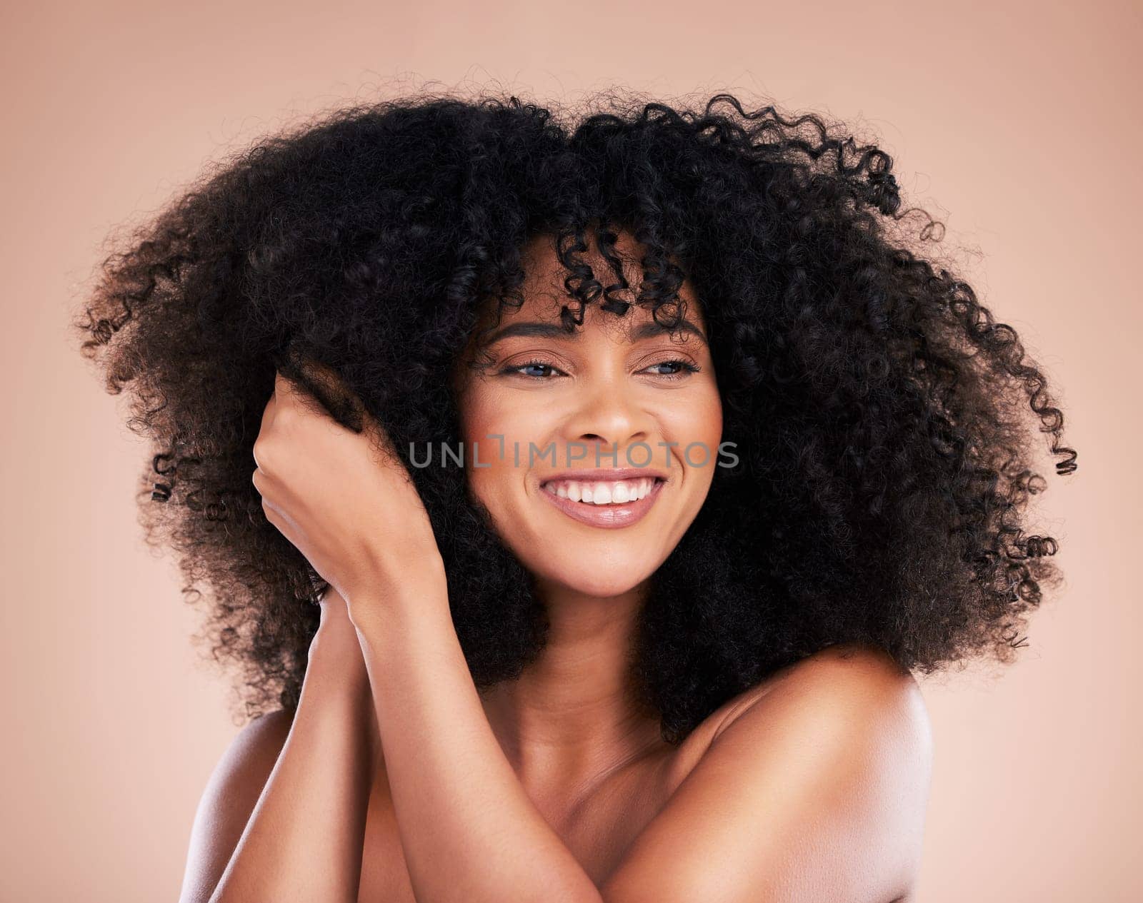 Curly hair texture, black woman and makeup of a young model with a healthy afro from salon treatment. Happy face, cosmetics and African person with wellness, skincare and smile from beauty in studio.