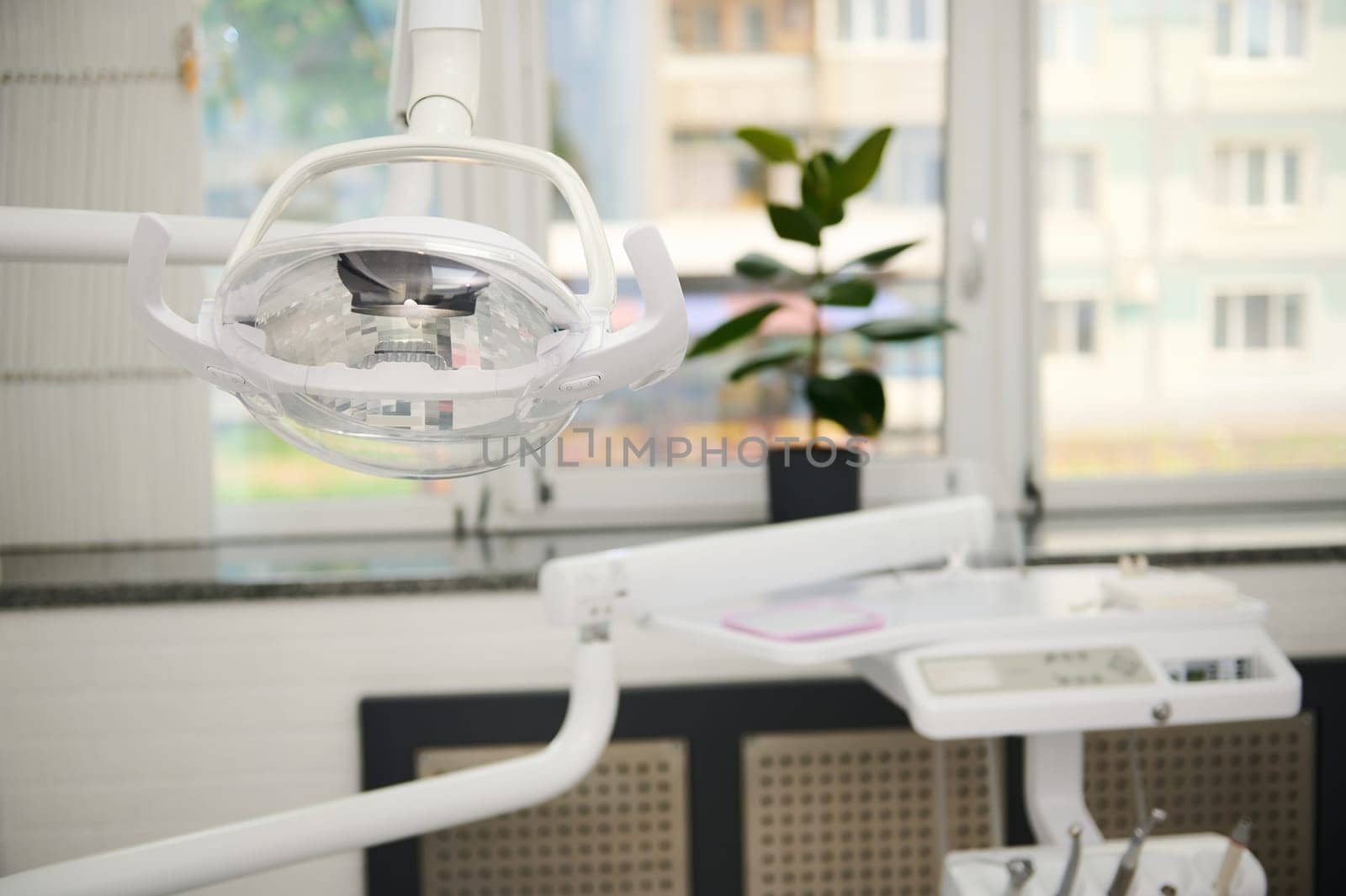Dental office interior. Dental equipment. Operating surgical lamp with directional LED light in modern dentistry clinic by artgf