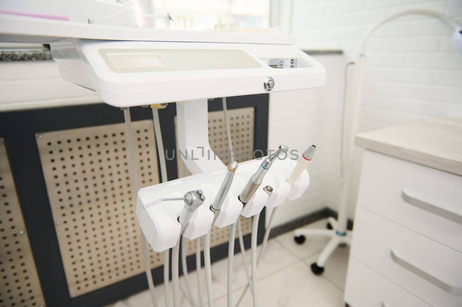 Modern equipment in while light dental office interior. Dentistry. Medical clinic, outpatient hospital. Copy advertising space. Selective focus on dental tools for treating teeth. Dental practice.