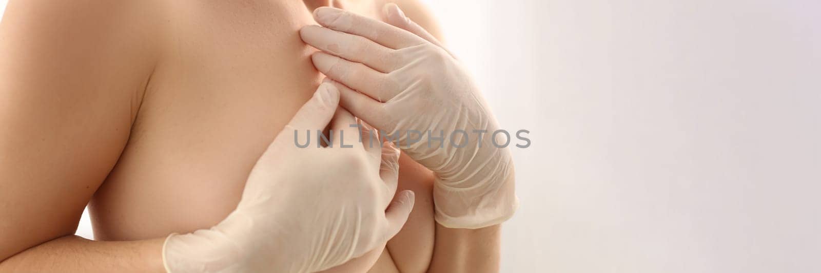Breast cancer and healthcare. Young woman with slim hot body holding breasts with hands on white background.