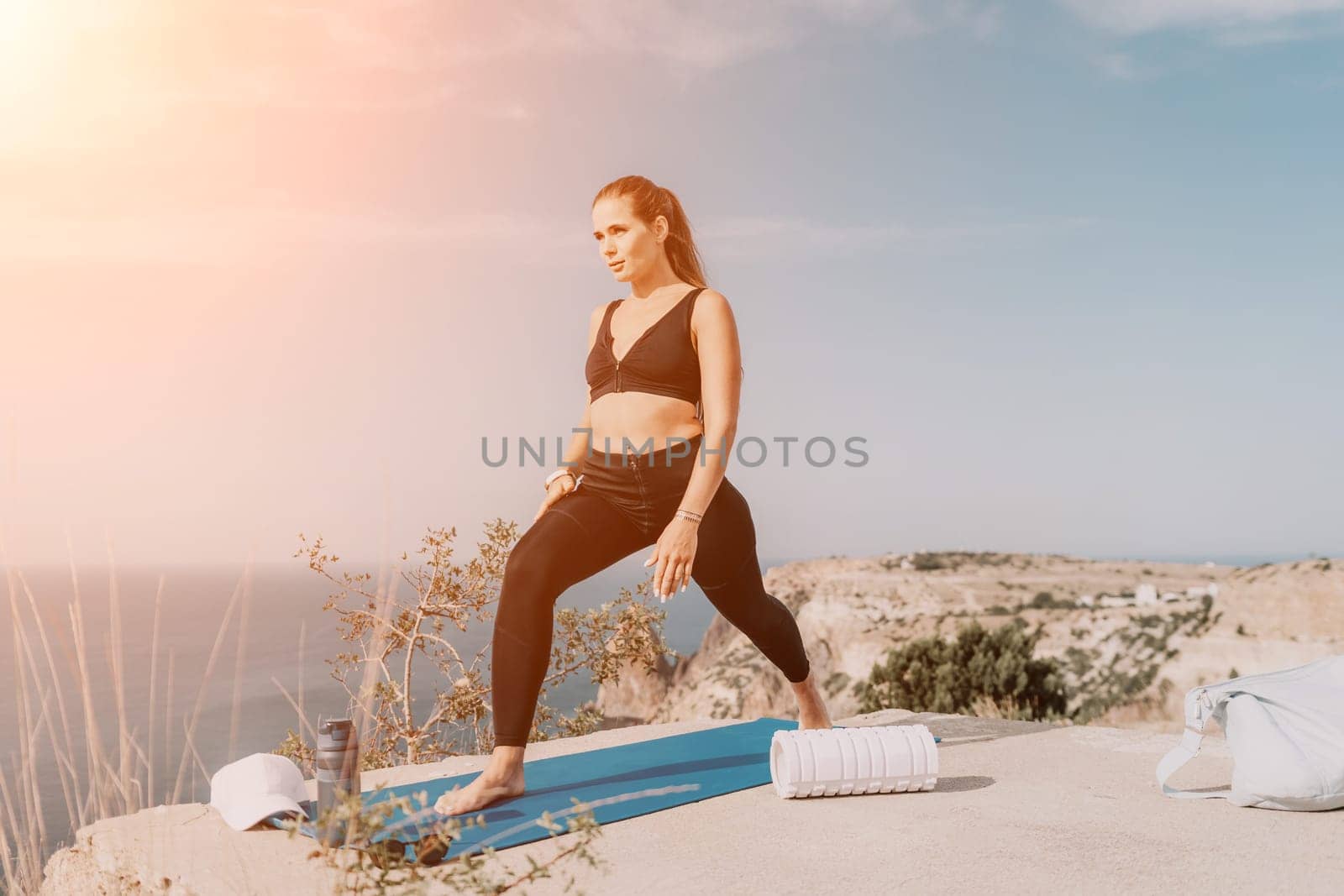 Fitness woman sea. Outdoor workout on yoga mat roller in park near to ocean beach. Female fitness pilates yoga routine concept. Healthy lifestyle. Happy fit woman exercising with rubber band in park. by panophotograph