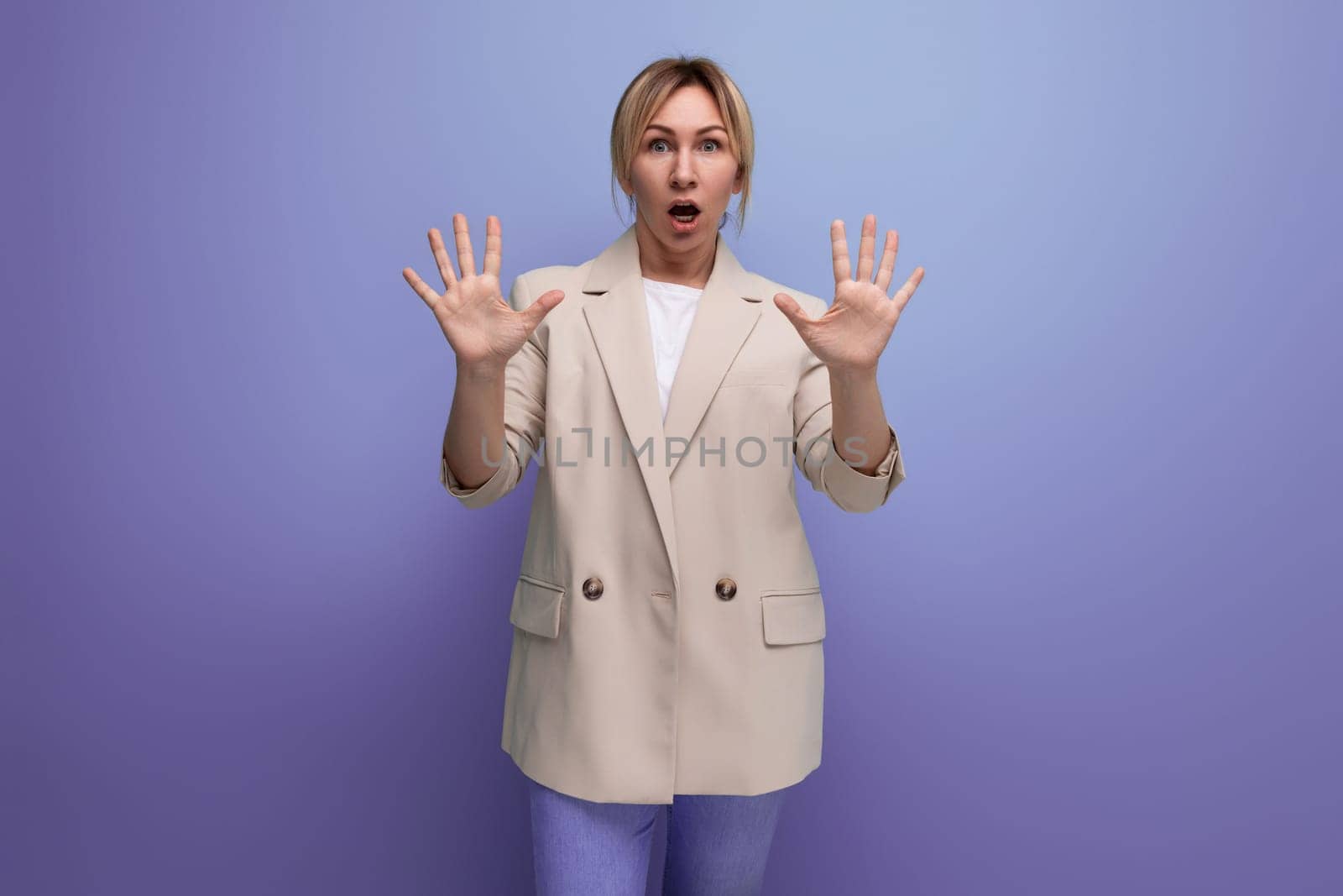 portrait of surprised successful blonde 30s business woman on studio background.