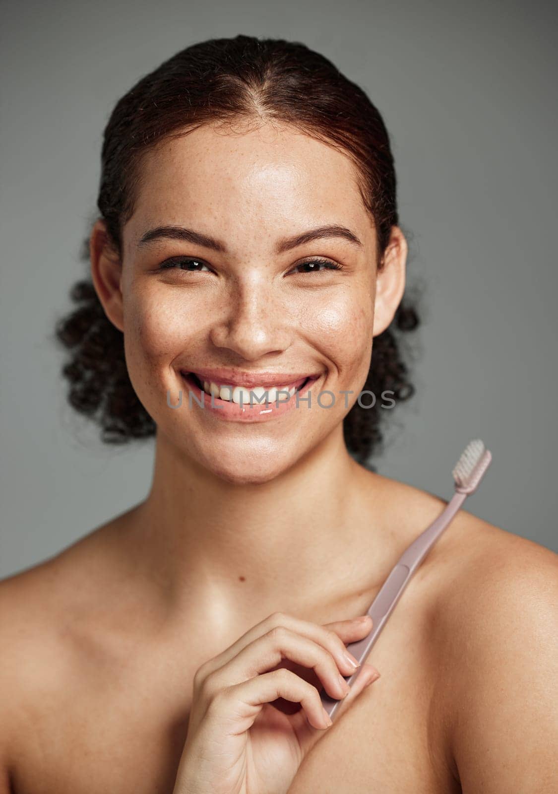 Brushing teeth, toothbrush and a woman portrait while happy about dental hygiene and teeth whitening. Face of a female with a smile for oral health, healthy mouth and self care on studio background by YuriArcurs