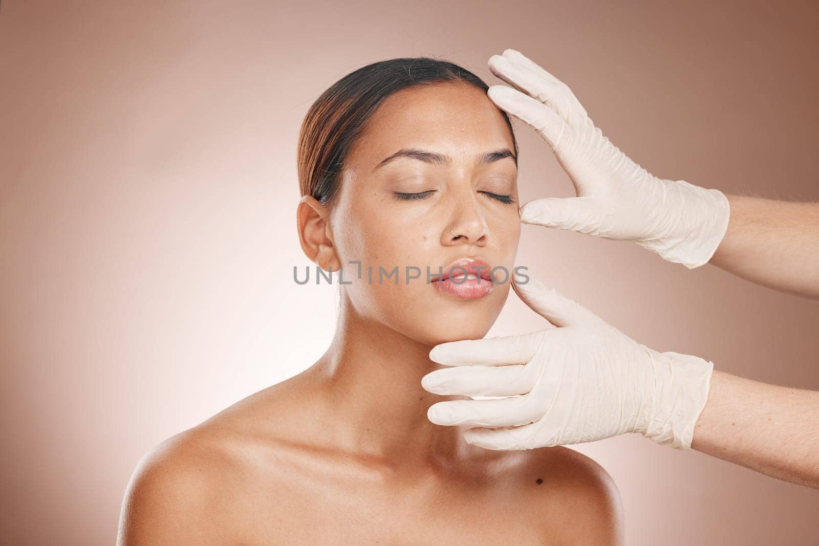 Plastic surgery, woman and doctor hands check face for botox, beauty implant and makeup cosmetics. Skincare consultation, facial and gloves for aesthetics, filler and body change on studio background by YuriArcurs