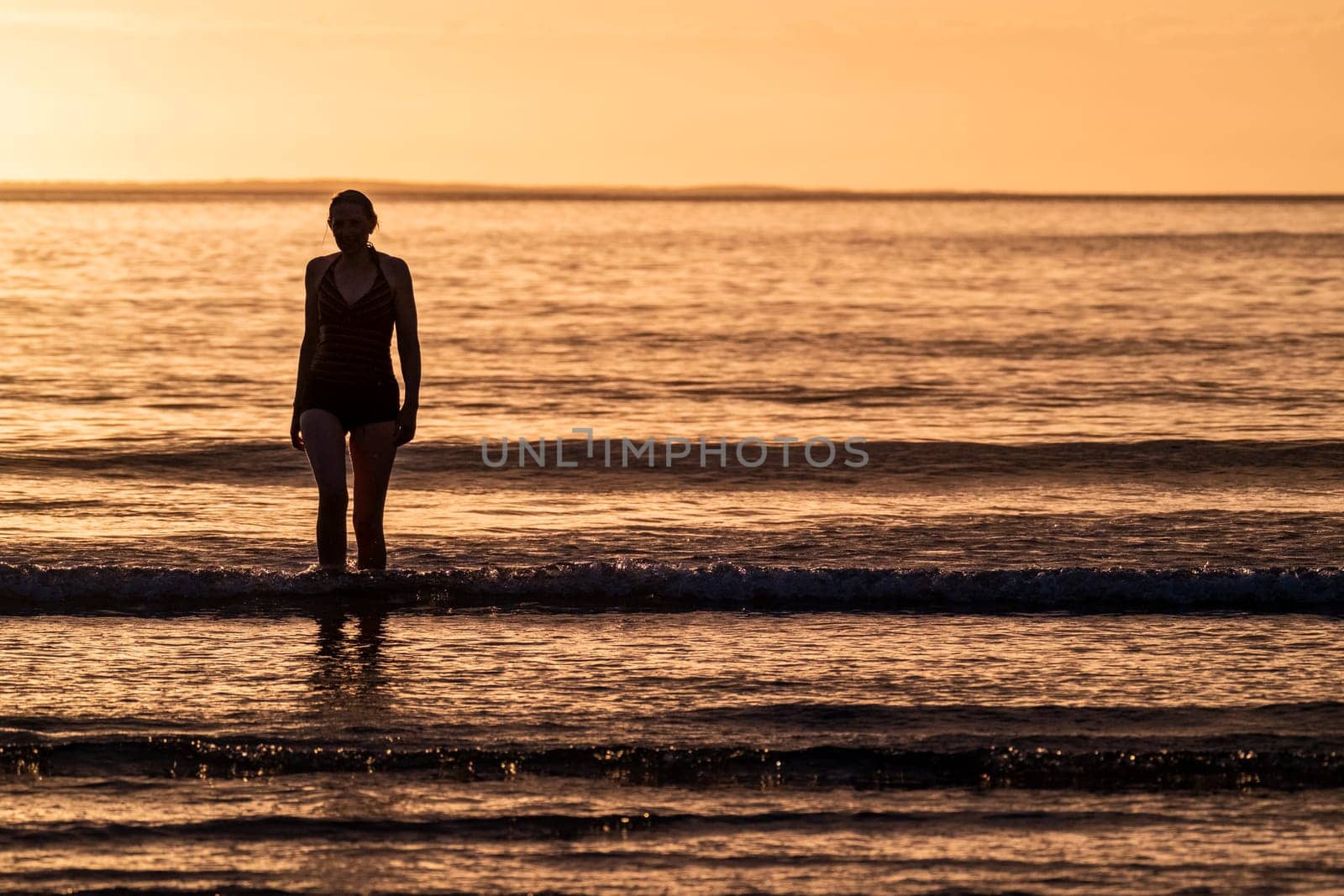 Silhouette of female swimmer going into the Atlantic ocean in Ireland by TLC_Automation