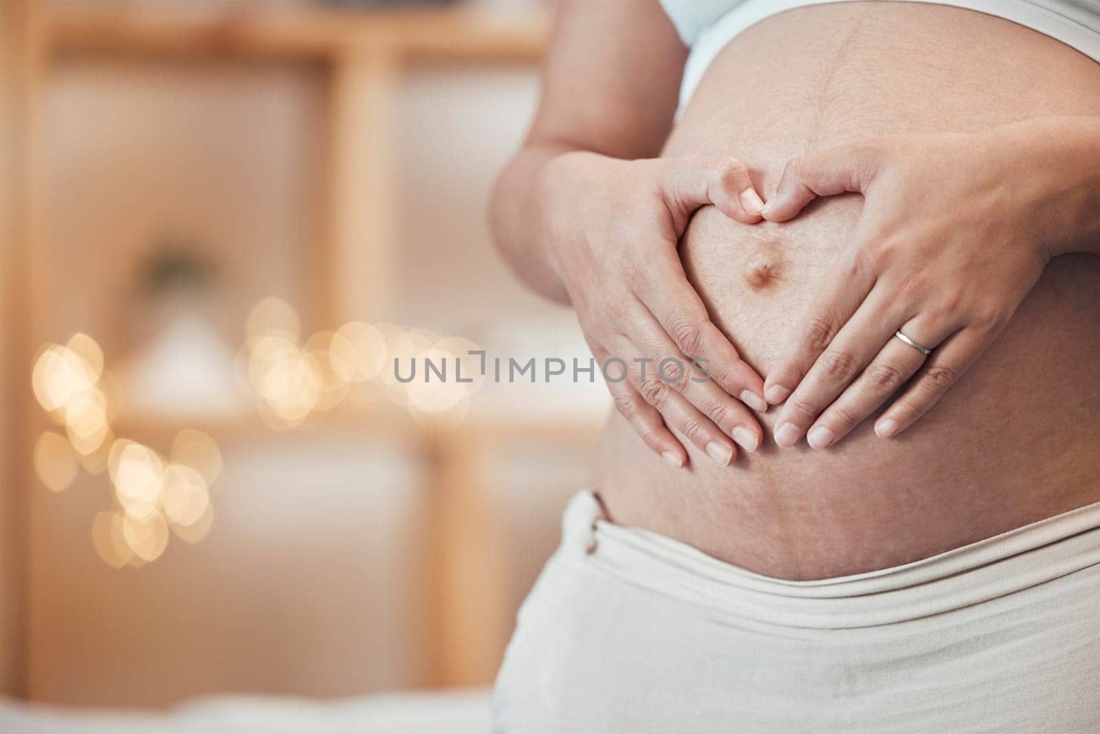 Pregnancy, love and hands in heart on stomach with woman excited for future family, children and baby. Motherhood, wellness and hand sign of pregnant woman for affection, wellness and childcare.
