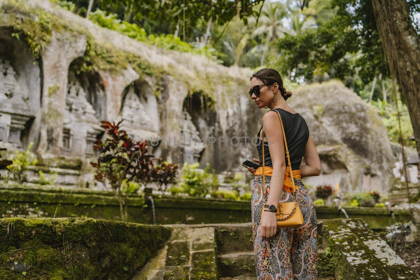 Close up shot of young lady tourist on Gunung kawi temple background by Popov