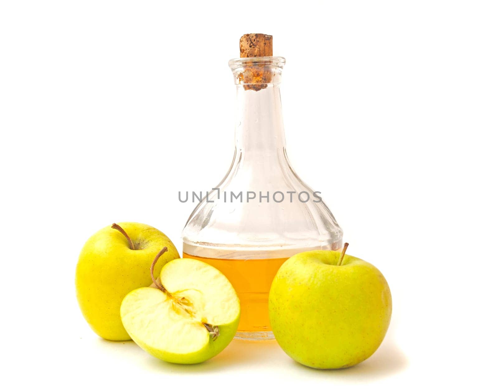 A decanter with apple cider vinegar, two and half apples isolated on white background