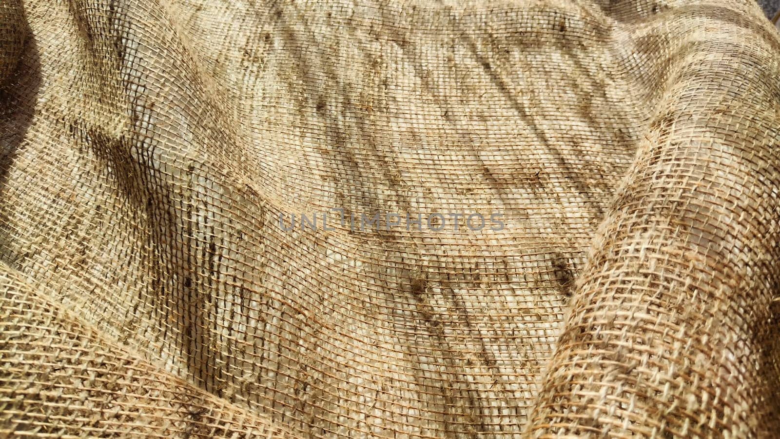 Natural fabric texture, frame and background of burlap. Rough crumpled burlap background. Selective focus