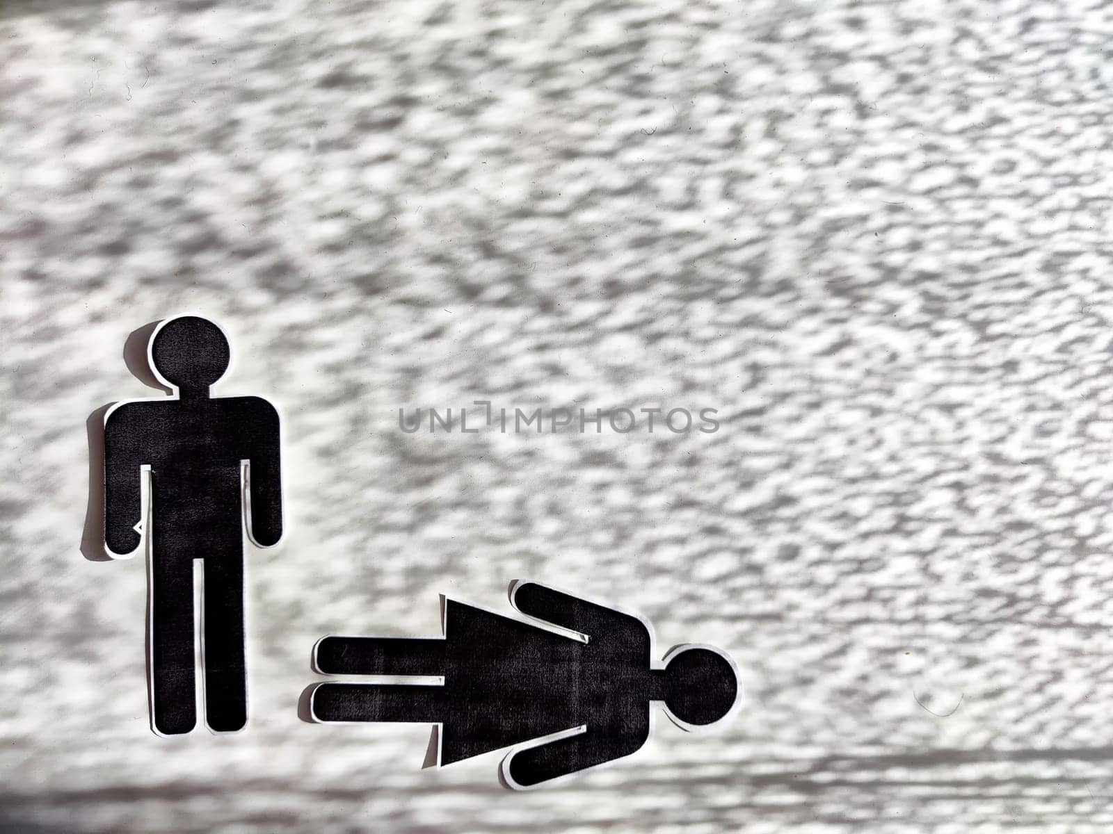 Concept of abuse, death, separation, divorce, dominance in couple. Bad addiction to alcohol or drugs. Paper black figurines of man and woman and one of them dominates. Abstract background, texture