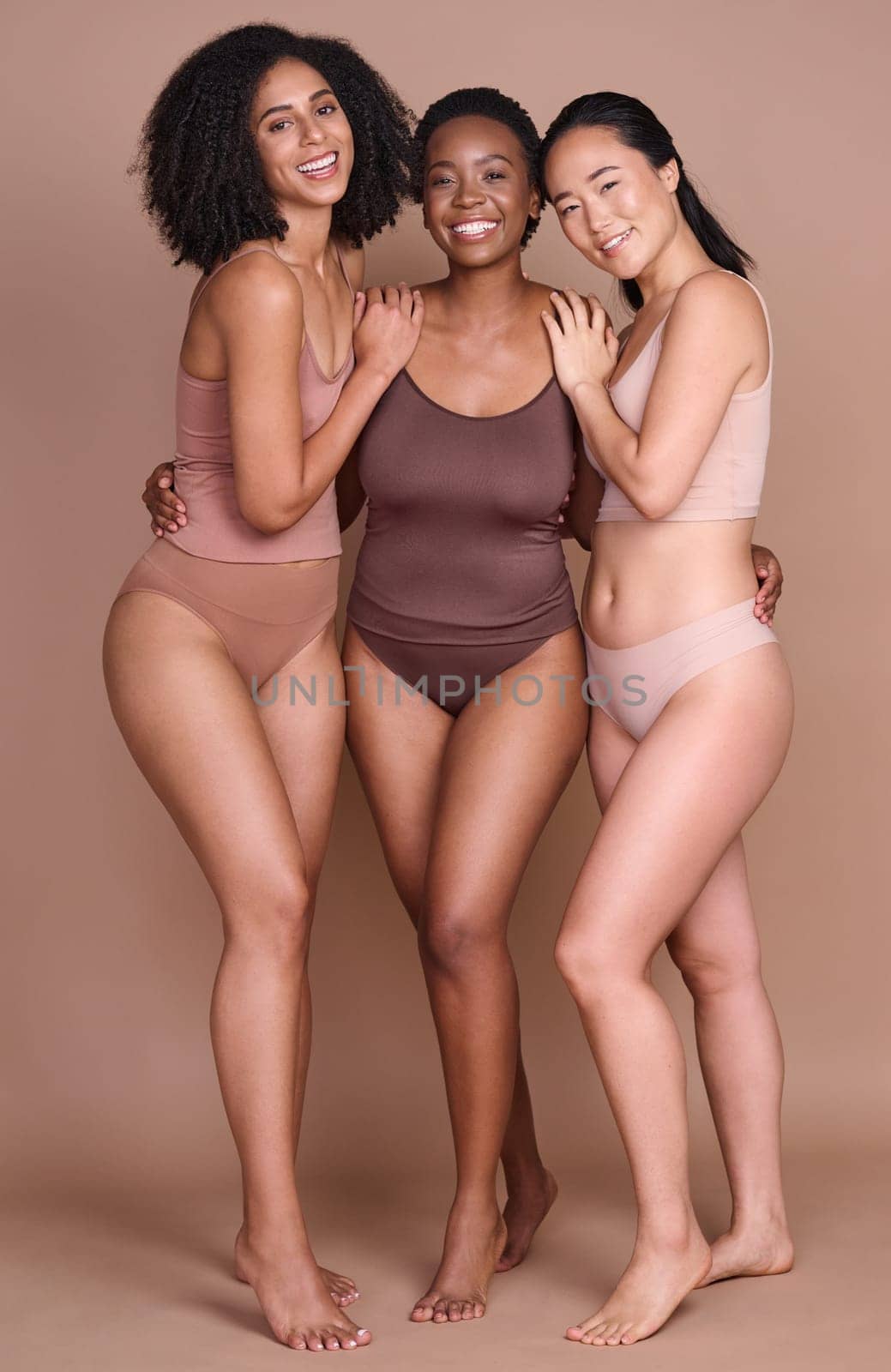 Girl friends, diversity and body positivity model group hug for portrait showing beauty and skincare. Underwear, happiness and glow of women together for dermatology and skin wellness support by YuriArcurs