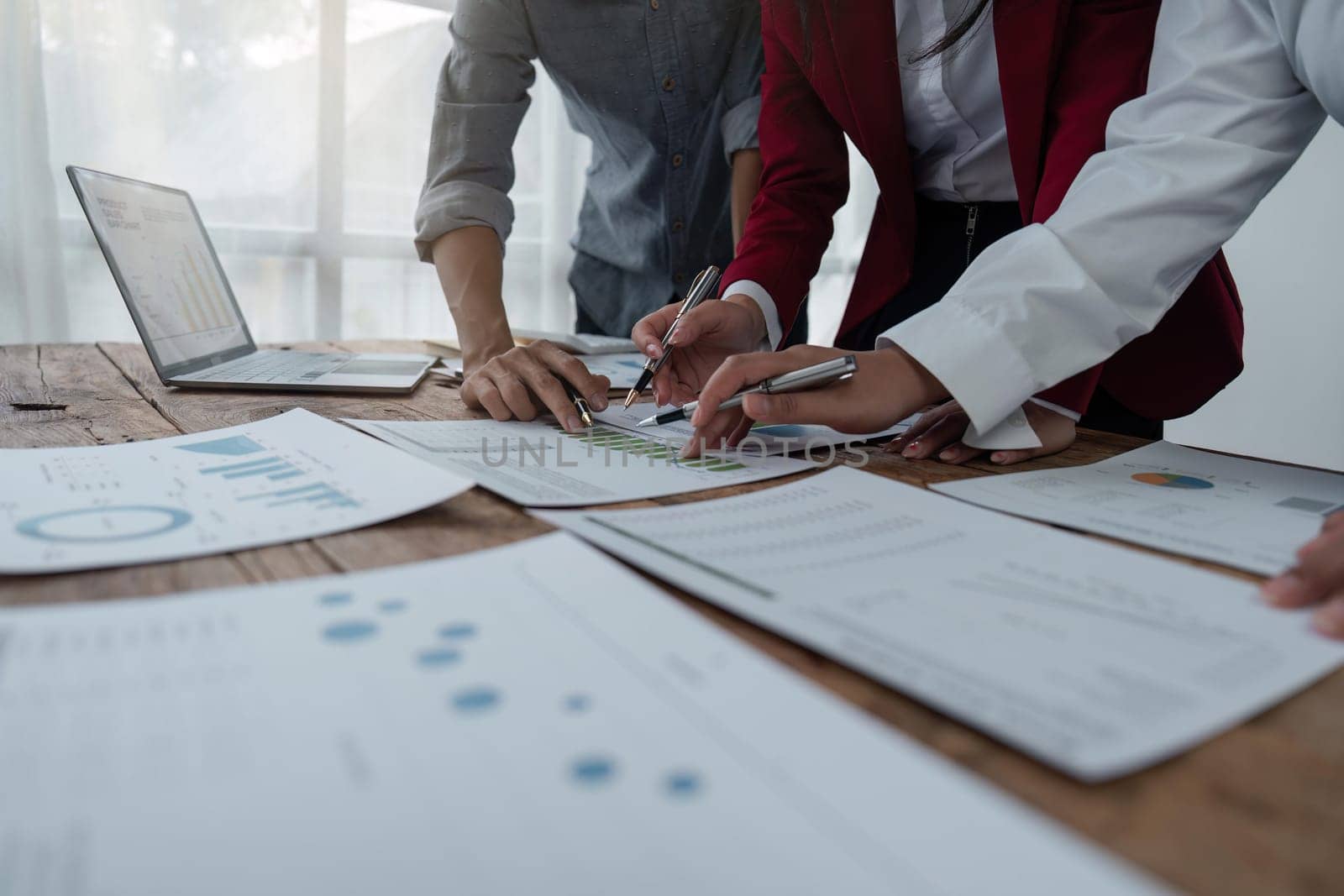 Businesspeople analyzing investment graph meeting brainstorming and discussing plan in meeting room at office, investment concept.