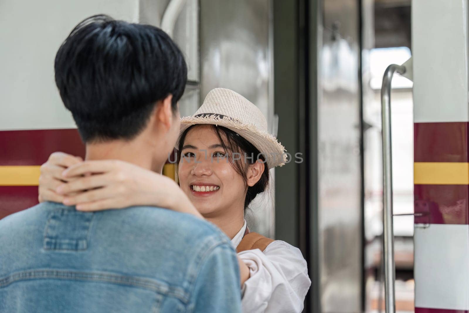 positive girlfriend hugging pleased man while locating near train.