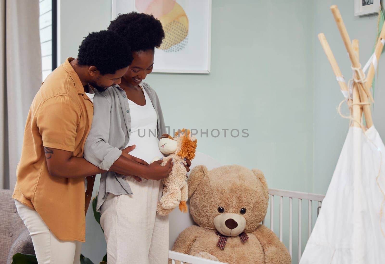 Love, teddy bear and pregnant couple in the nursery with excitement while preparing for their baby. Happy, pregnancy and young African man with his maternal wife looking at toy together in bedroom. by YuriArcurs