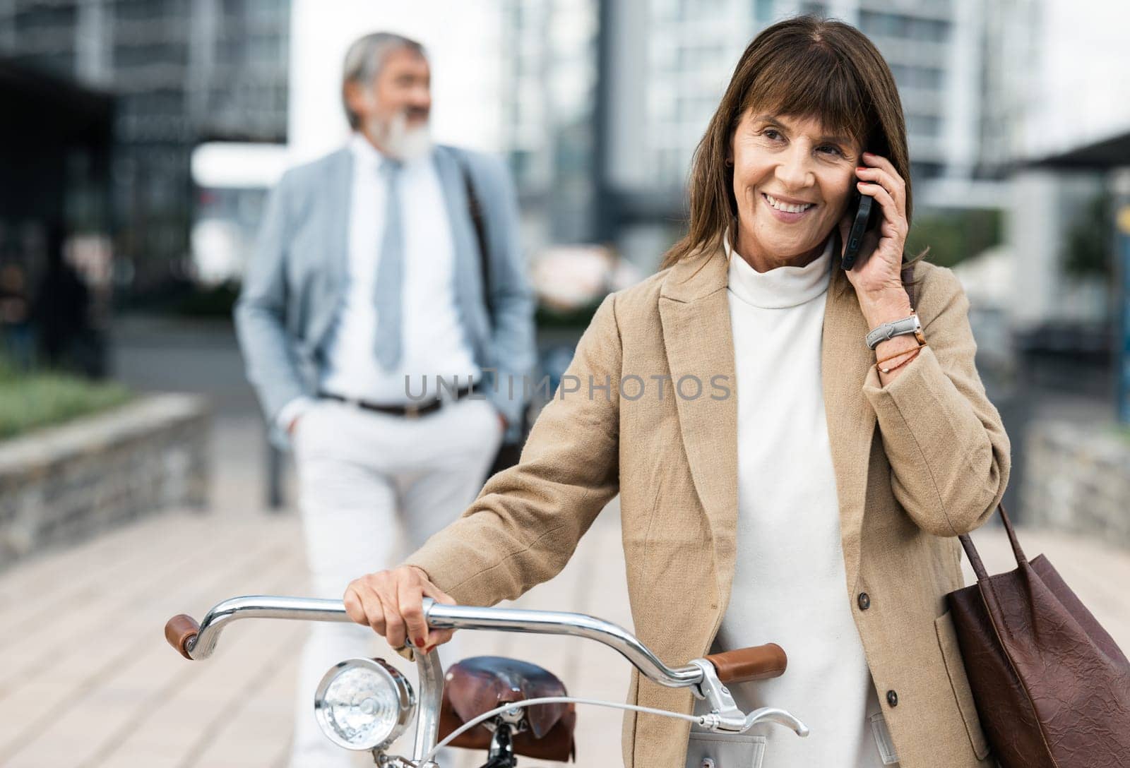 Phone call, bicycle and senior woman cycling to work while talking, speaking and in 5g conversation with business contact. Eco friendly transportation, communication and city person walking with bike by YuriArcurs