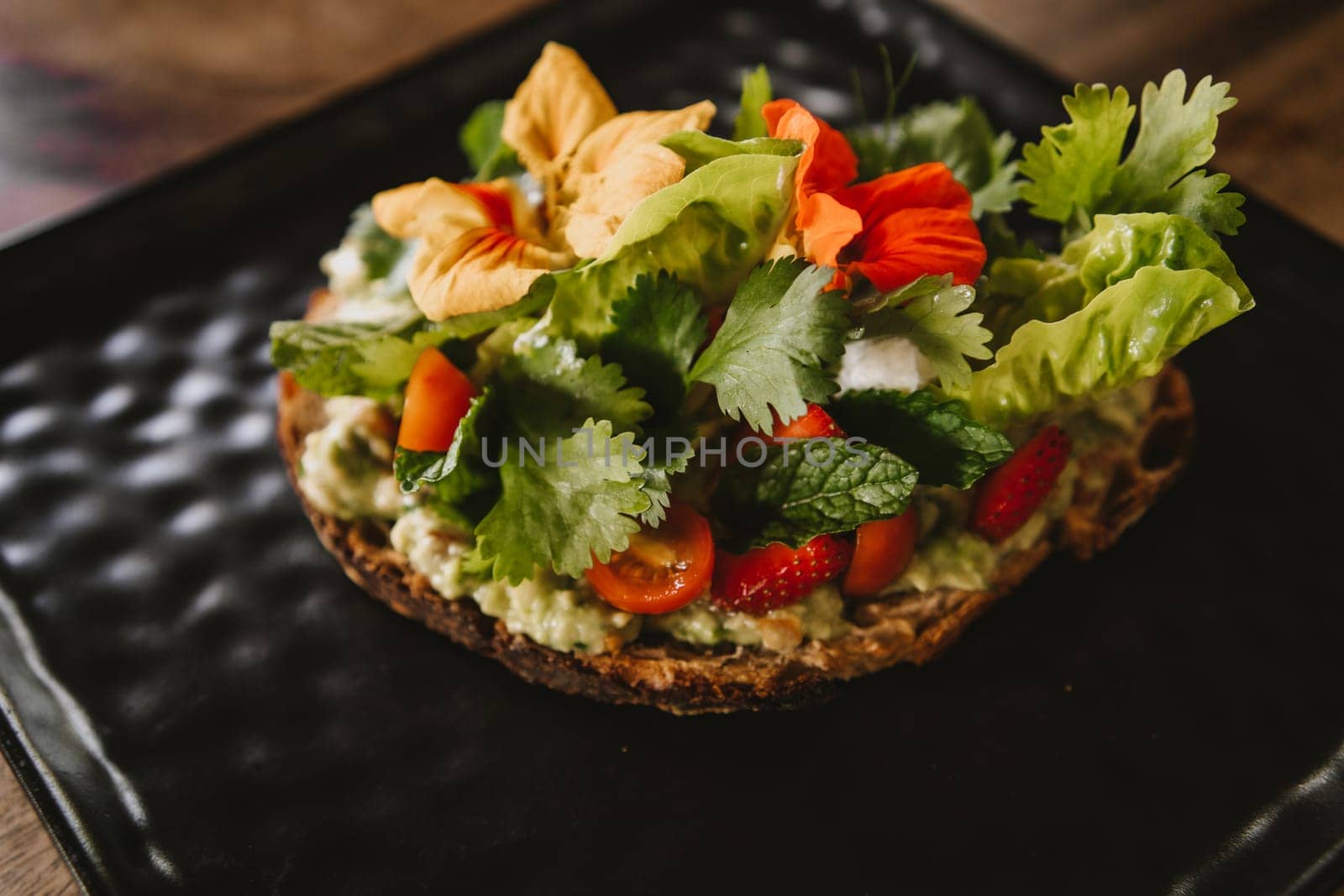 Close up shot of avocado bruschetta with tomatoes and herbs by Popov