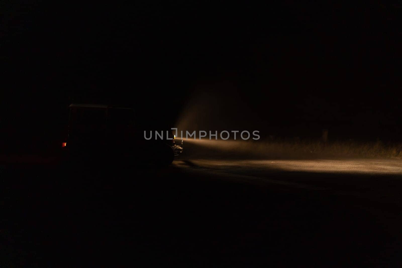 Front view of car with headlights on in the night by Popov