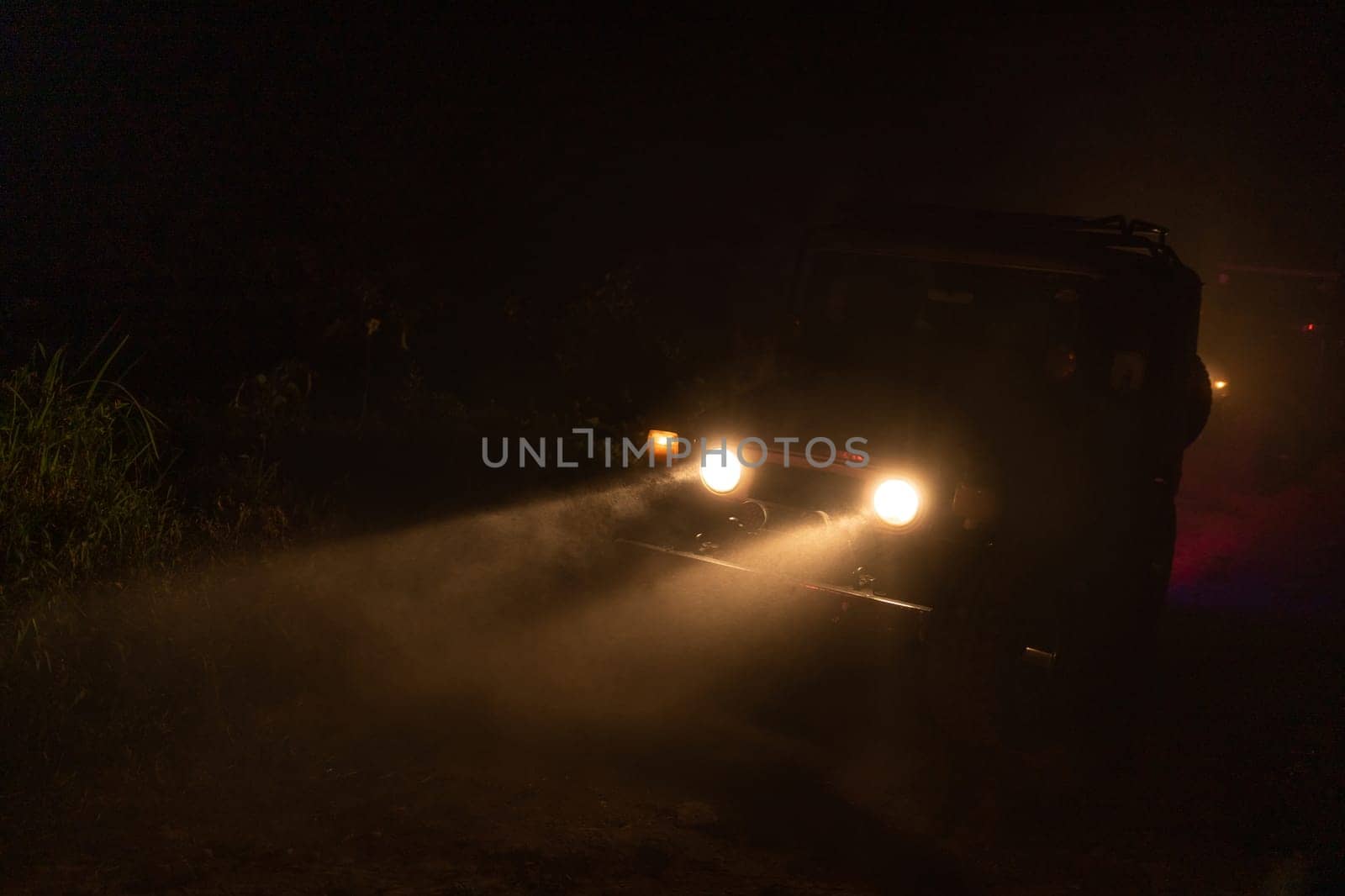 Car with headlights on in the night. Tourism safari travelling car through midnight