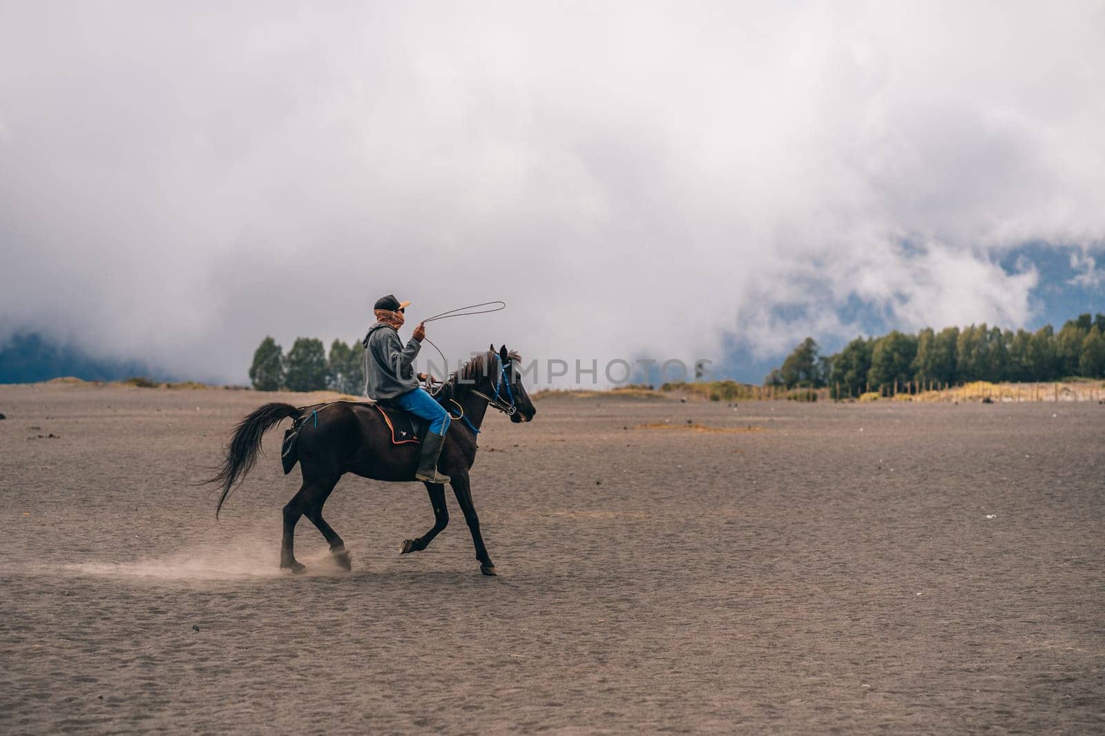 Bromo mount unrecognized horseman riding in the savanna desert by Popov