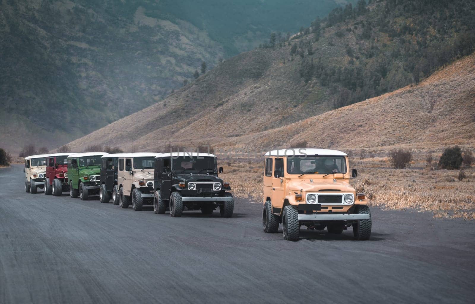 Bromo mountain travel jeeps driving in a row. Rental vehicle for discovering Semeru National park