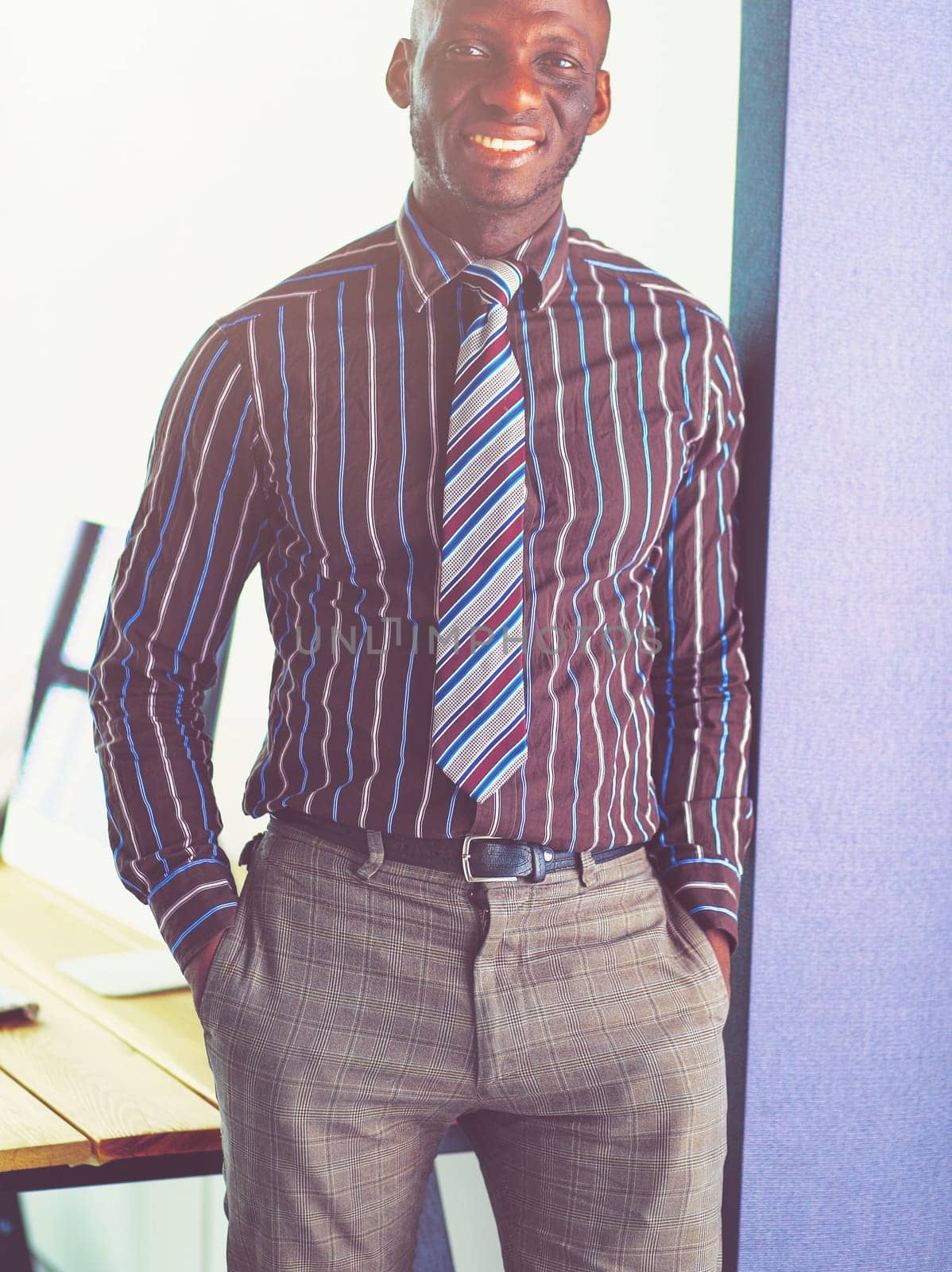 Portrait of an handsome black businessman standing in office.