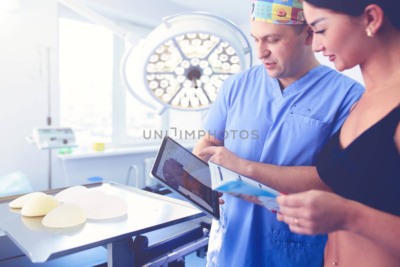 Doctor showing young patient her chest in his office at the hospital.