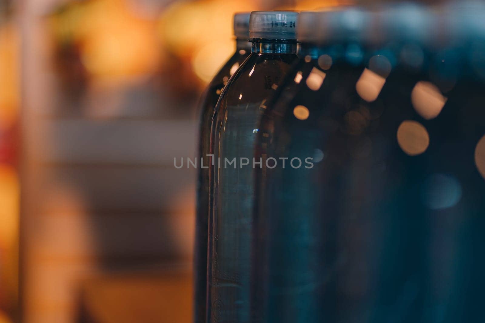 Close up shot of raw water plastics bottles. Line of blue mineral aqua bottles, clear natural beverage