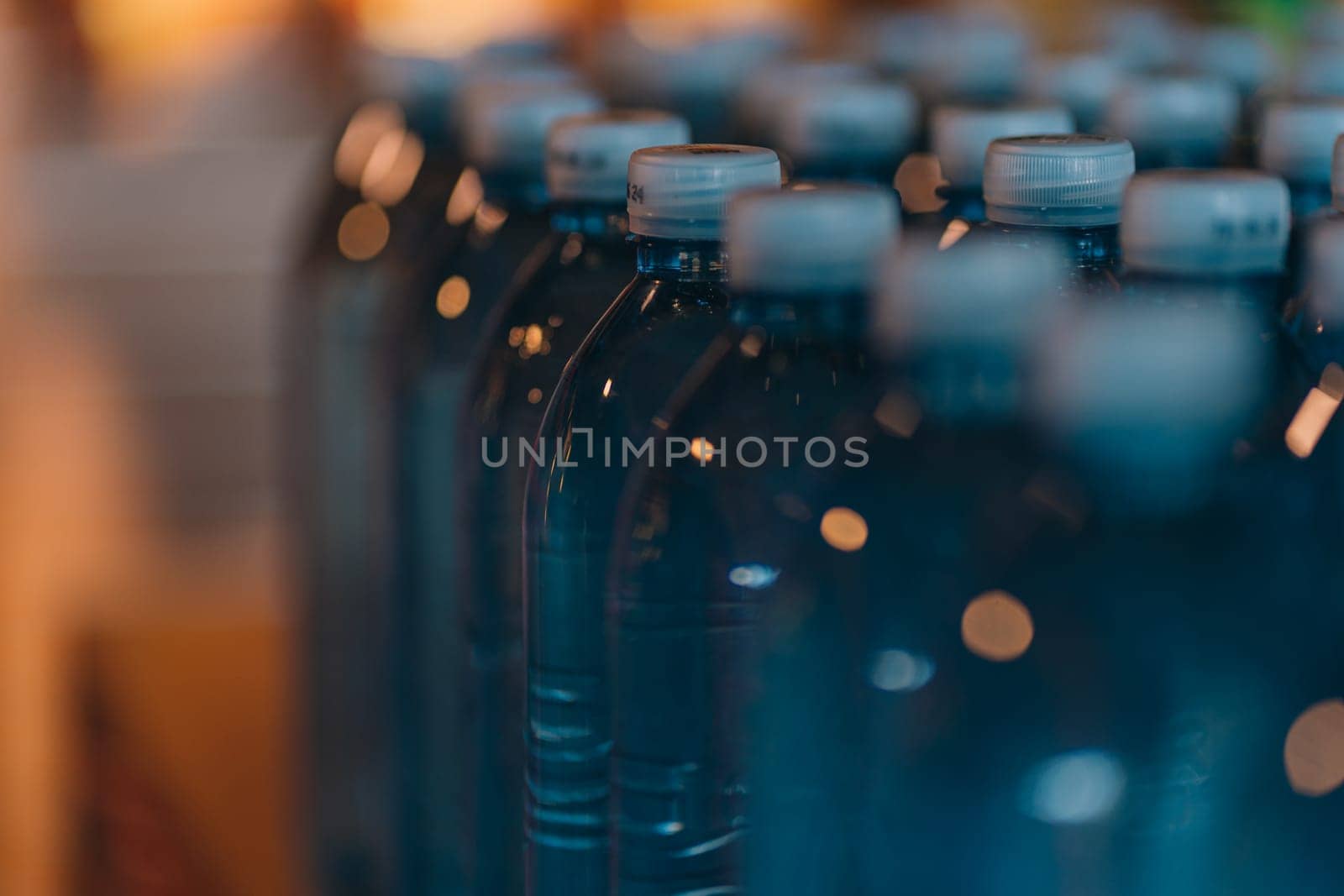 Close up shot of raw water plastics bottles. Line of blue mineral aqua bottles, clear natural beverage