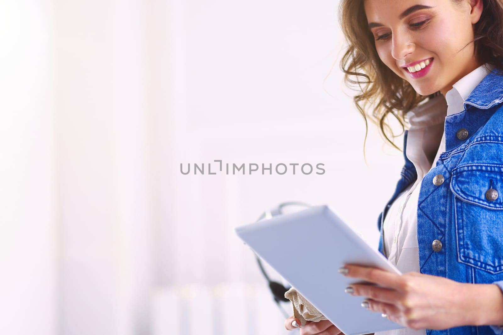 Smiling woman drinking coffee and using tablet in the cafe