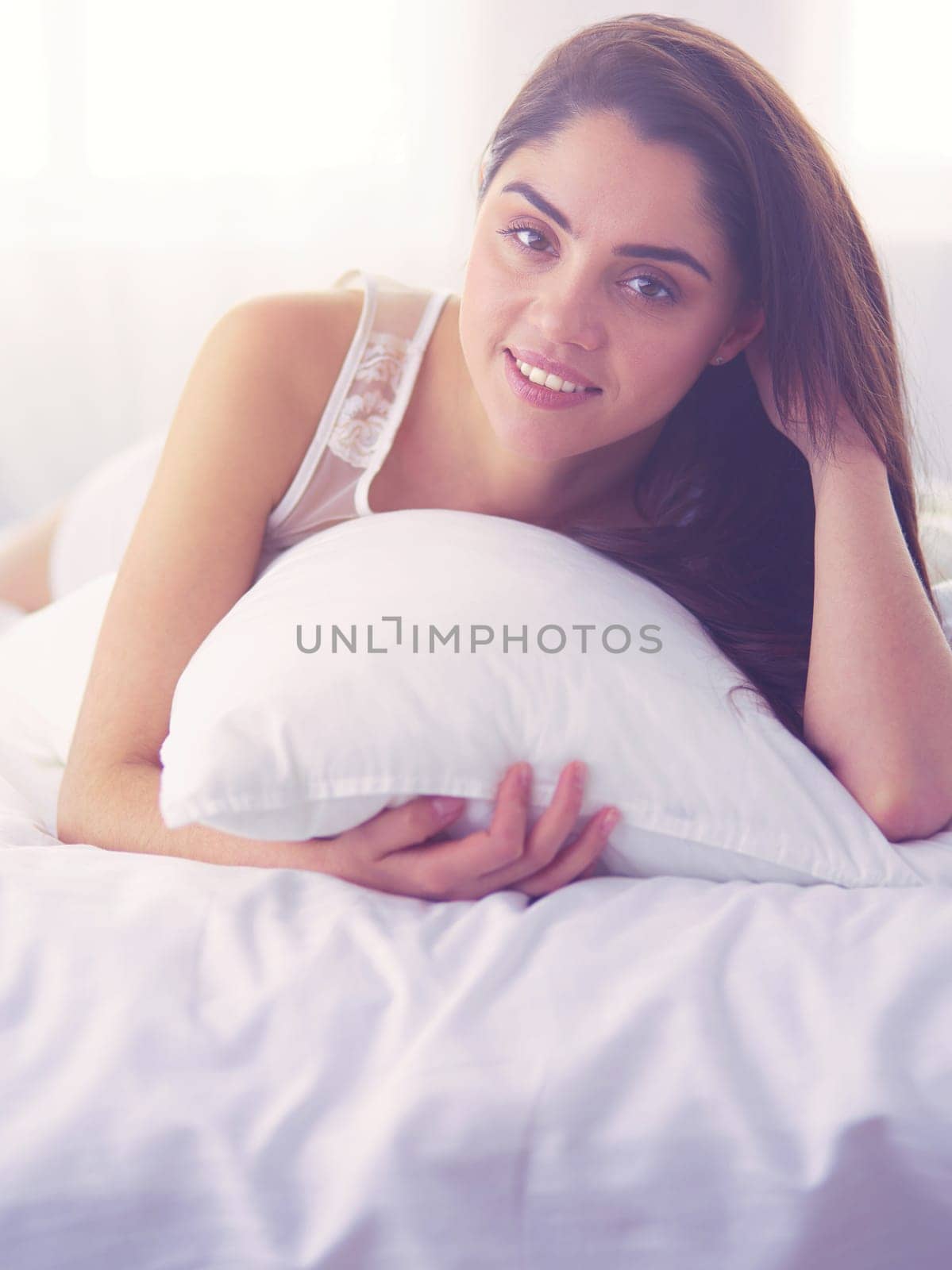 Pretty woman lying down on her bed at home.