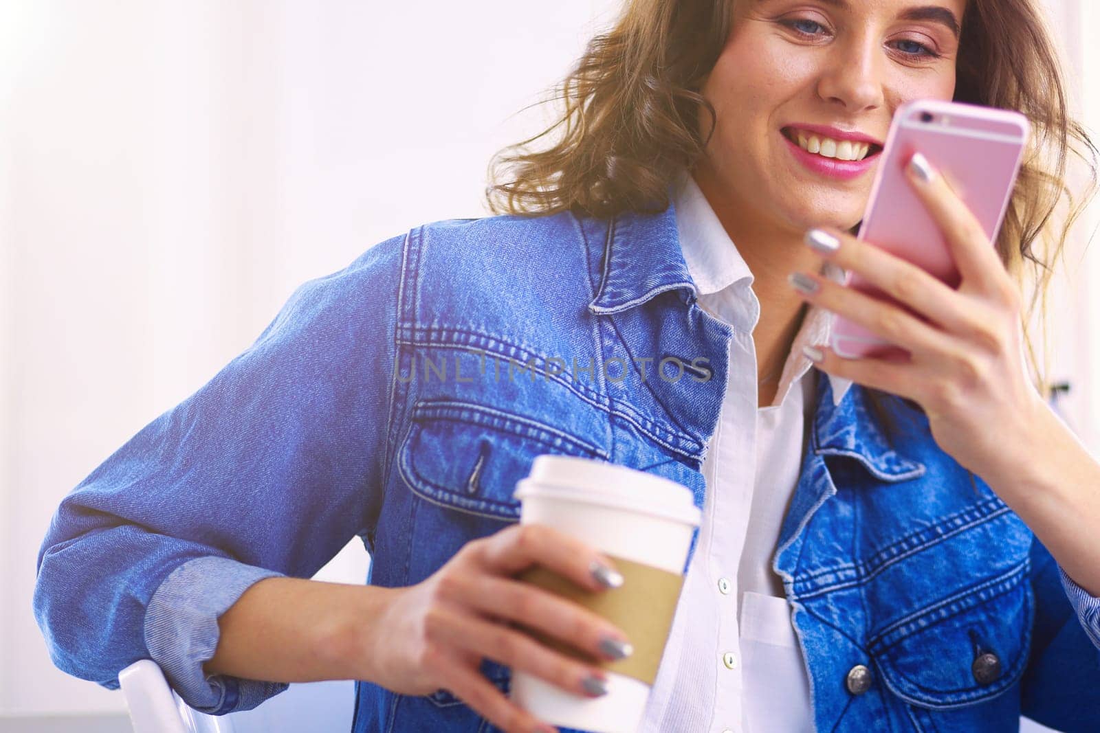 Young woman at cafe drinking coffee and talking on the mobile phone