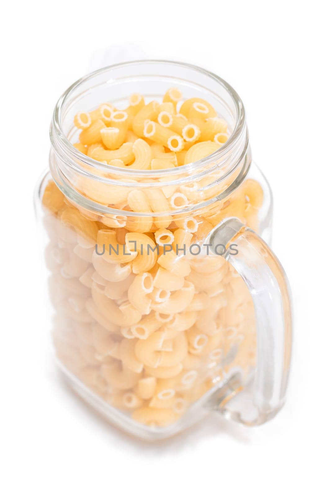 Uncooked Chifferi Rigati Pasta in Glass Jar Isolated on White Background. Fat and Unhealthy Food. Classic Dry Macaroni. Italian Culture and Cuisine. Raw Pasta - Isolation