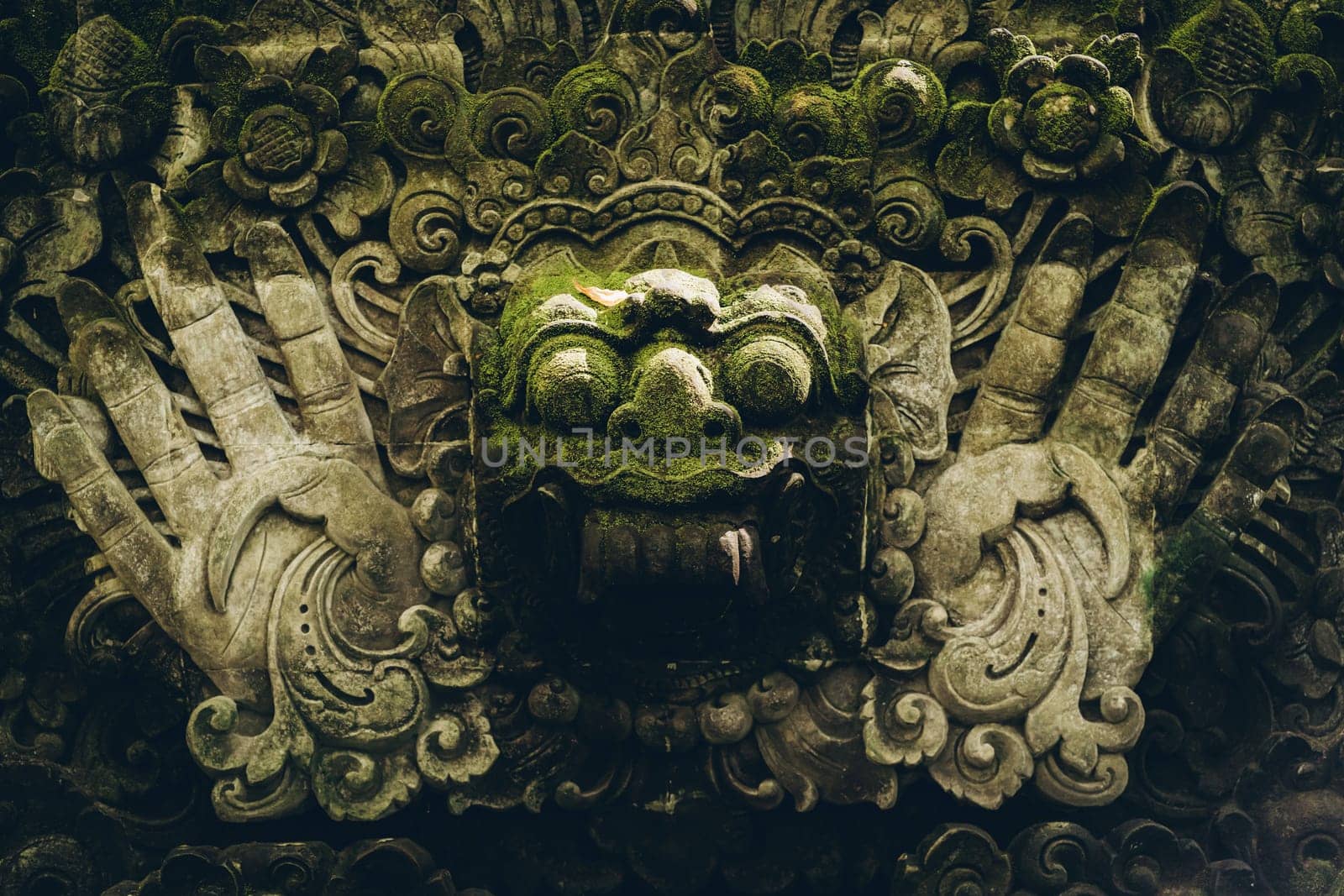 Close up shot of stone face statue in monkey forest. Balinese sculpture architecture in sacred monkey sanctuary