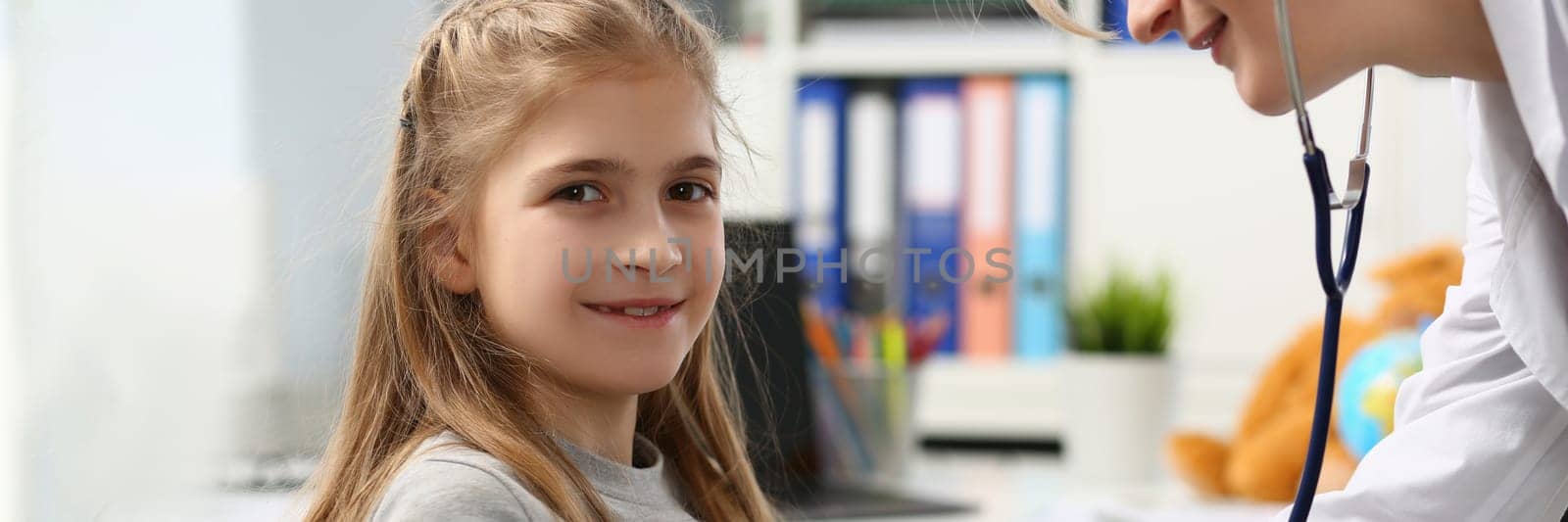 Portrait of cheerful little child at pediatrician appointment. Health care, pediatrics and medicine concept
