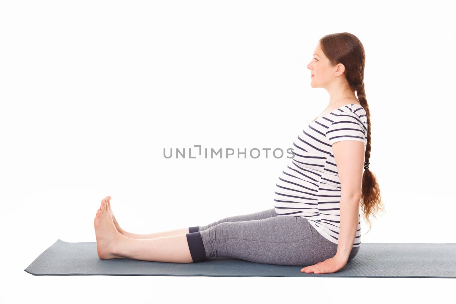 Pregnant woman doing yoga asana Dandasana by dimol