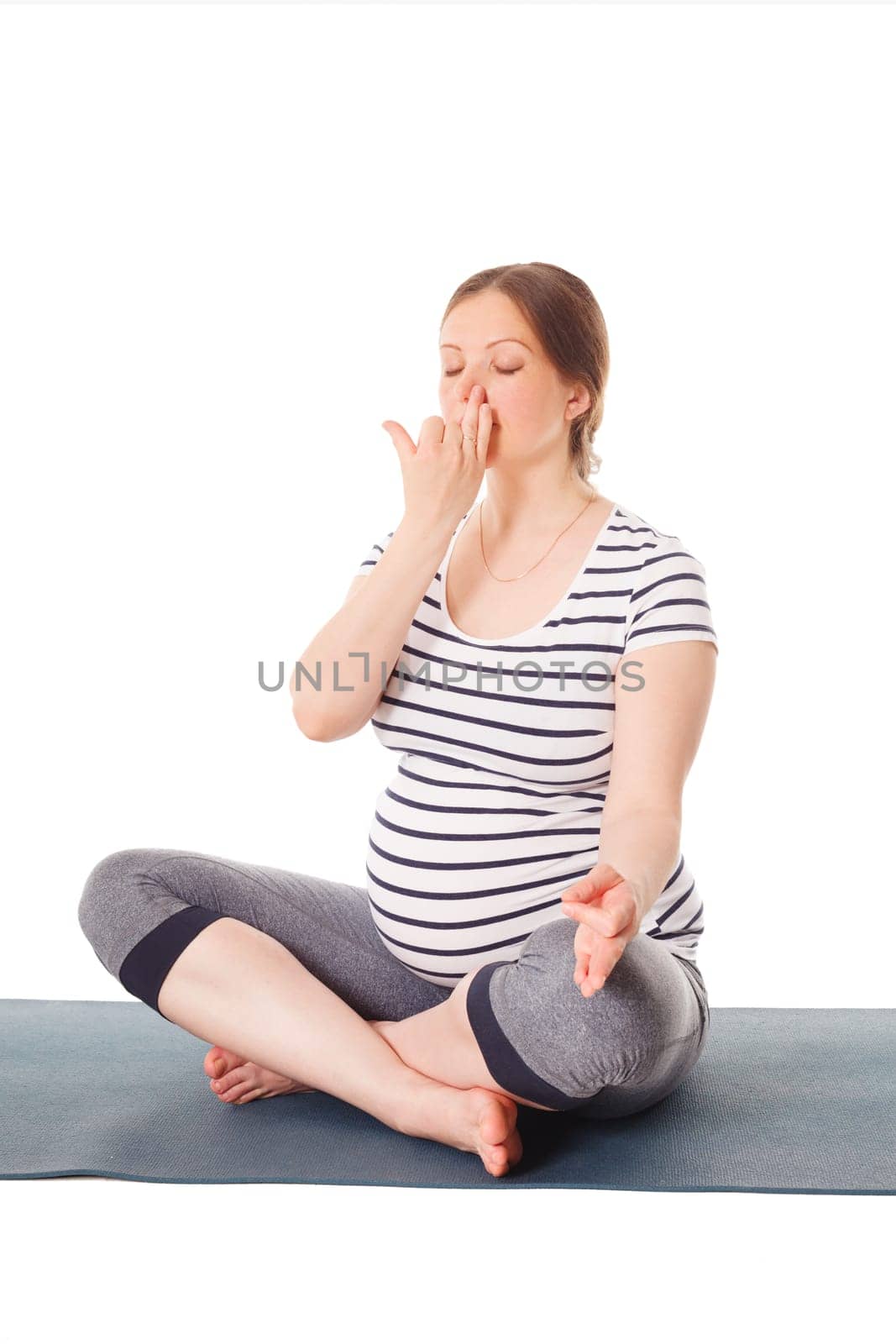 Pregnancy yoga exercise - pregnant woman doing yoga breathing exercise Pranayama isolated on white background