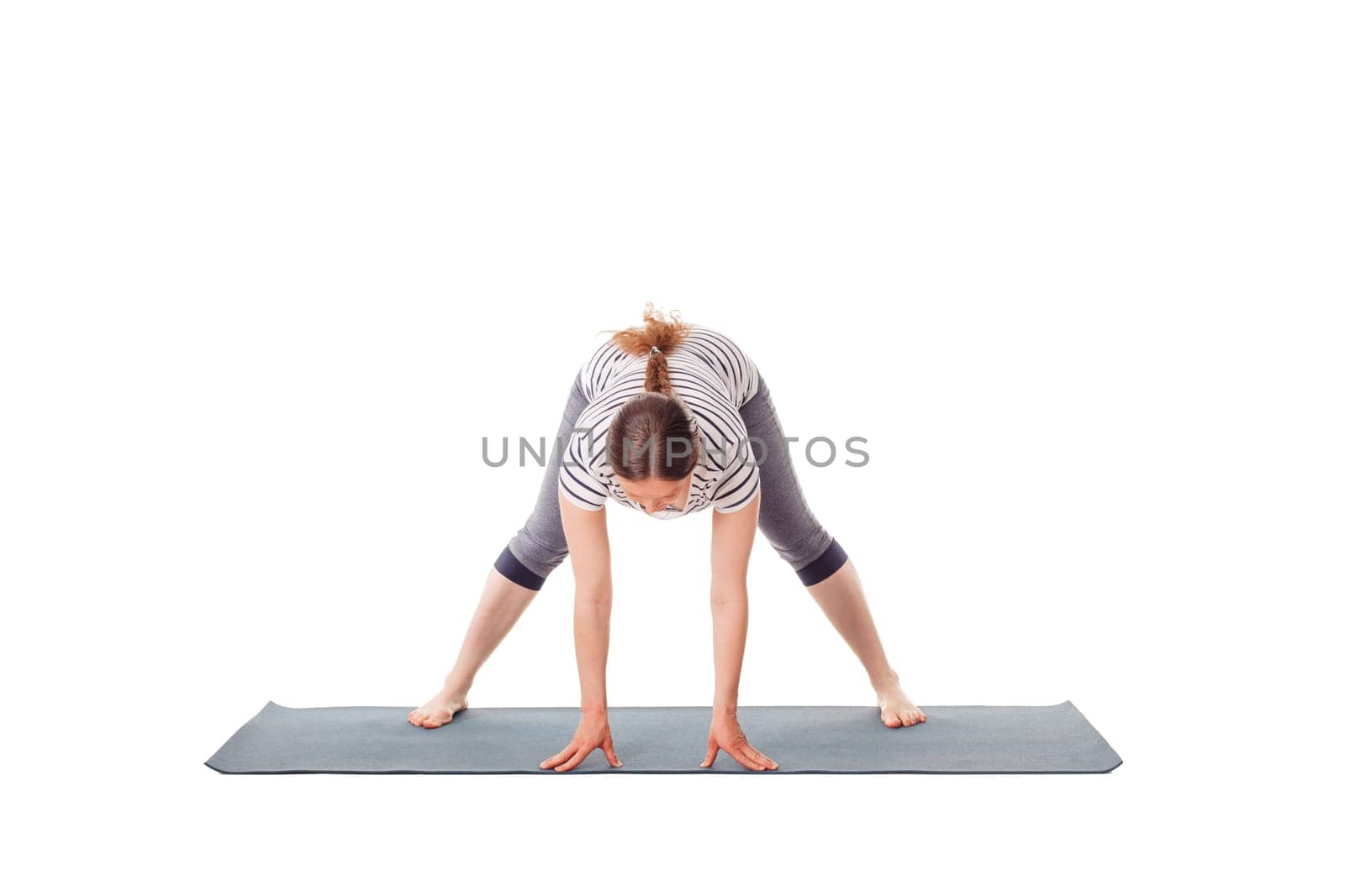Pregnancy yoga exercise - pregnant woman doing yoga asana prasarita padottanasana A Wide-Legged Standing Forward Bend isolated on white background