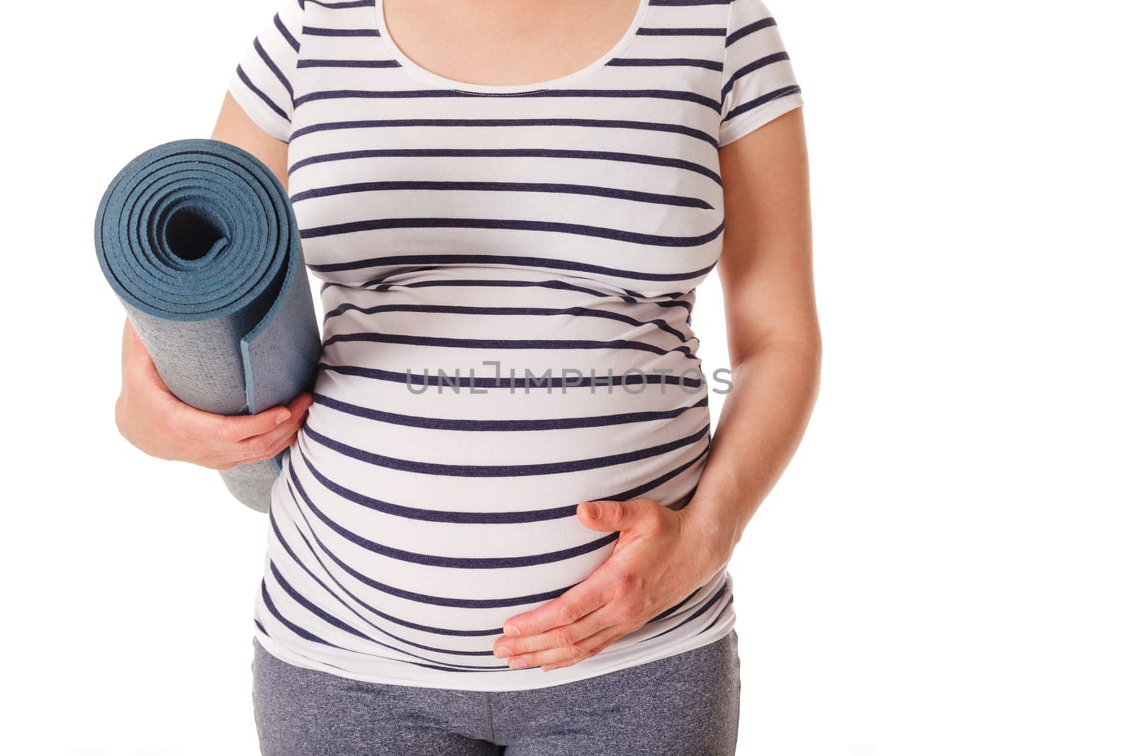 Pregnant woman standing with yoga mat by dimol