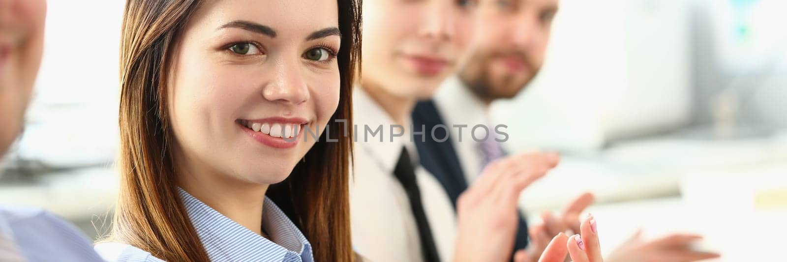 Business smiling people hands applauding at conference. Successful young business lady at meeting greets boss