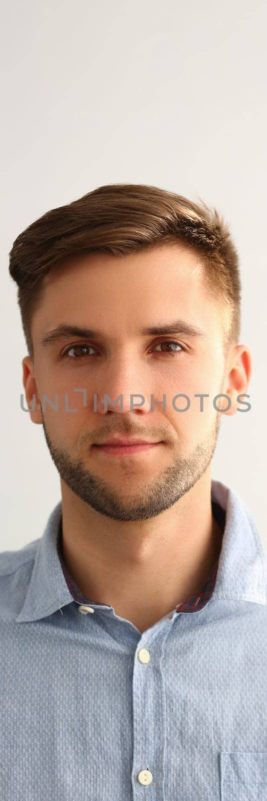 Portrait of handsome young man in blue shirt. Serious smart successful leader man