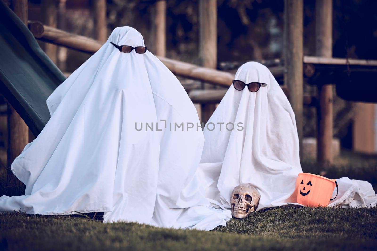 Halloween, glasses and people in ghost costume for trick or treat, global dress up day or fun on playground grass field. Fear fantasy, horror and relax friends role play scary phantom monster at park.