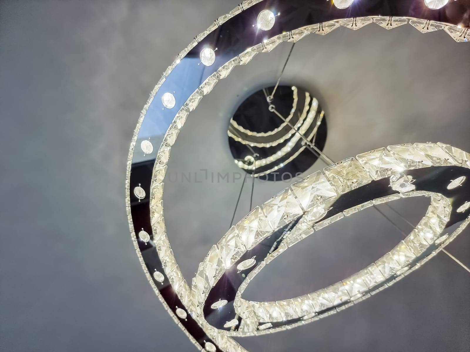 bright three circles one bigger than another with crystal clean stones with shine and light inside big luxury modern lamp.