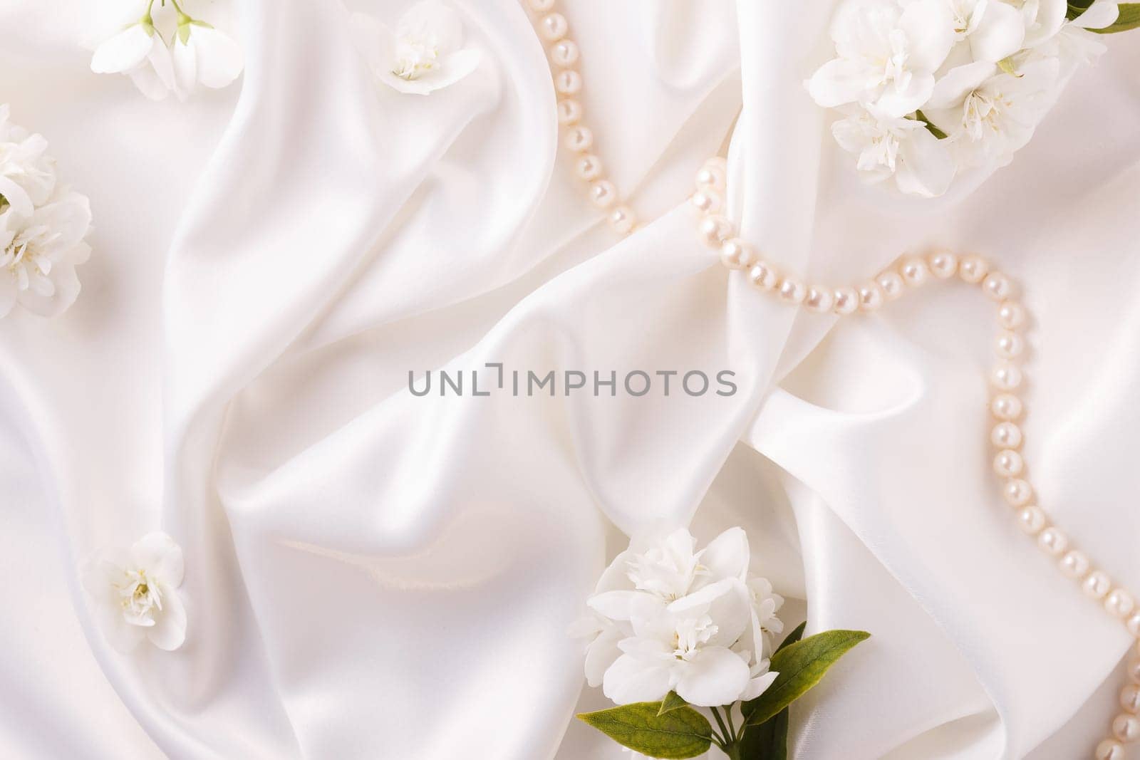Background blank with flowers and pearls on a white flowing satin. by lara29