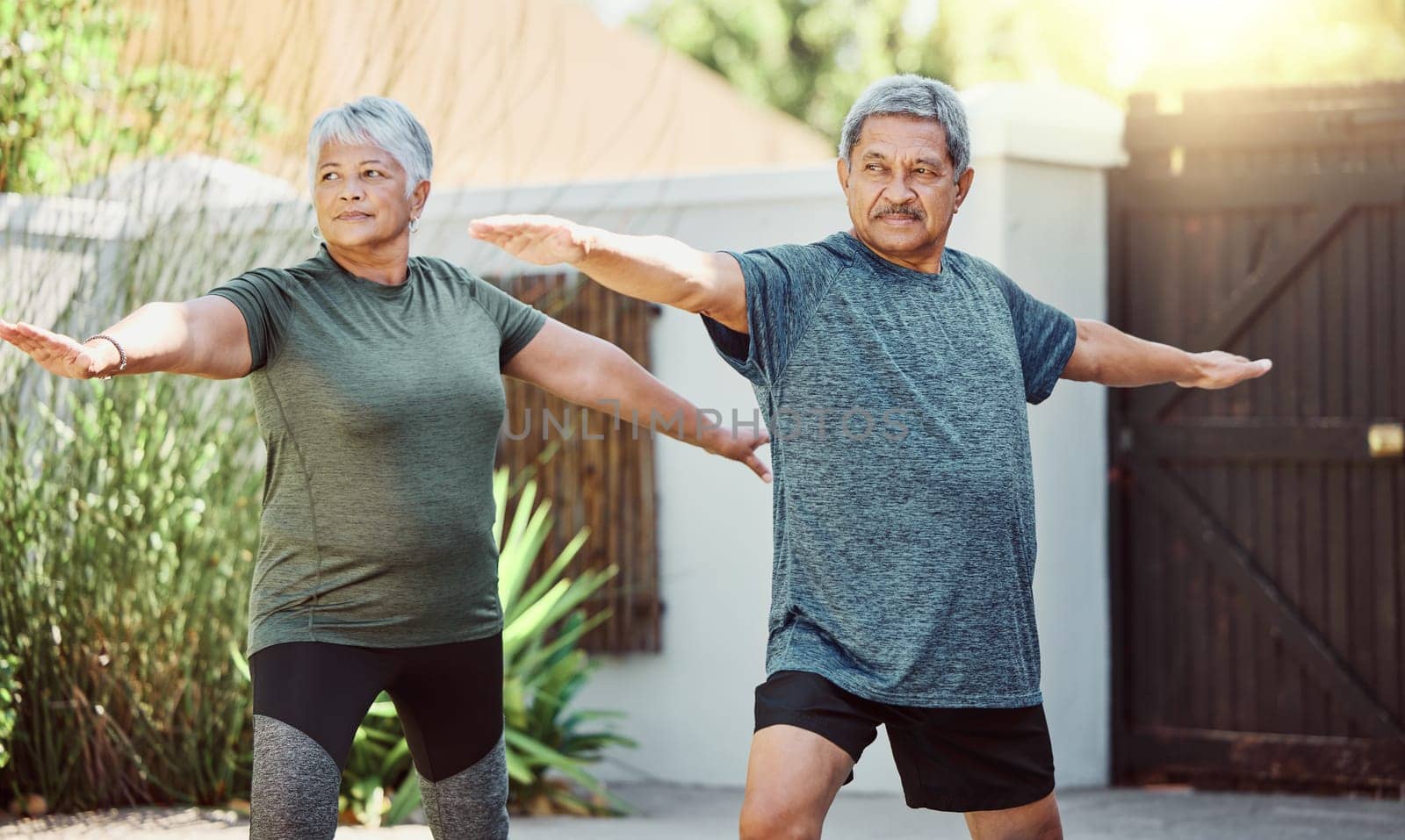 Exercise, yoga and health with a senior couple outdoor in their garden for a workout during retirement. Fitness, pilates and lifestyle with a mature man and woman training together in their backyard by YuriArcurs