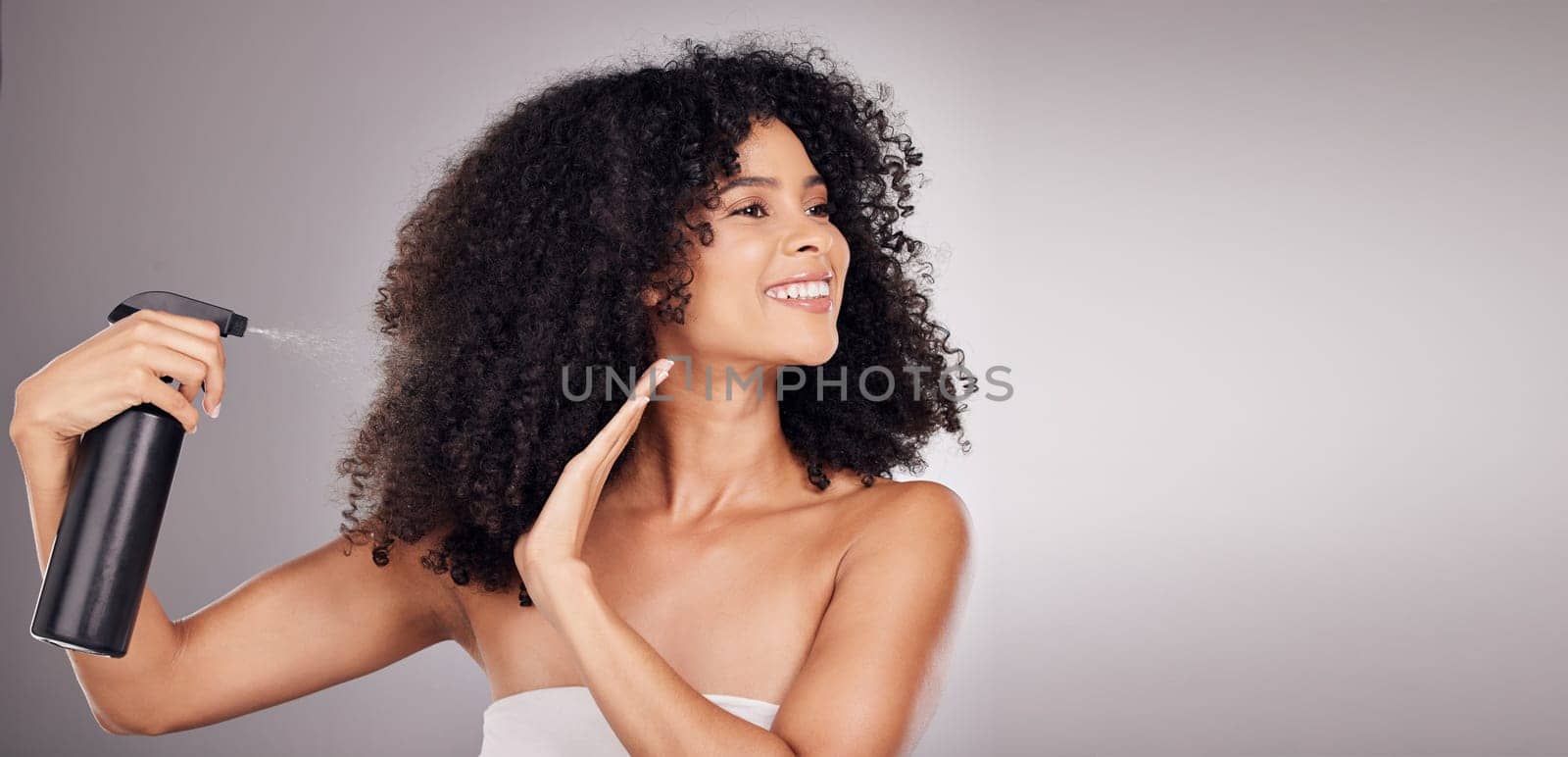 Hair, spray and black woman with product for natural wellness, growth and shine on gray background. Beauty face, salon copy space and happy girl smile with hairspray, cosmetics and keratin treatment by YuriArcurs