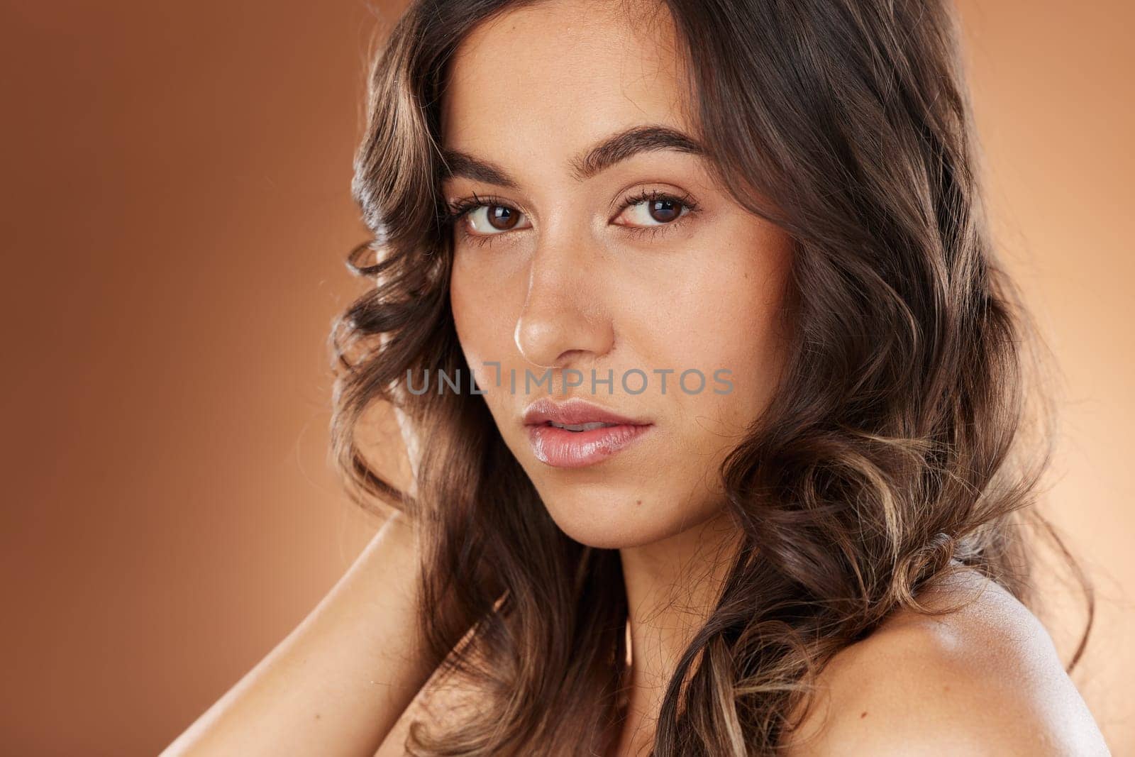 Woman, face skincare or curly hairstyle on studio background in Brazilian keratin treatment, self love or healthcare wellness. Portrait zoom, brunette color or beauty model and natural texture waves by YuriArcurs