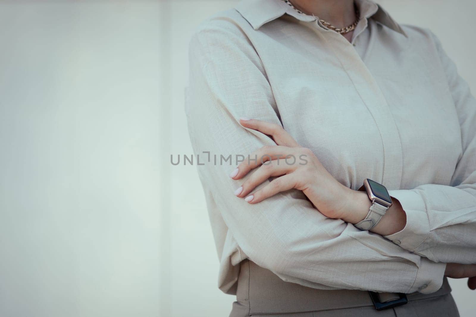 Women's office or business style in clothes. Restrained female image in beige tones with a smart watch.