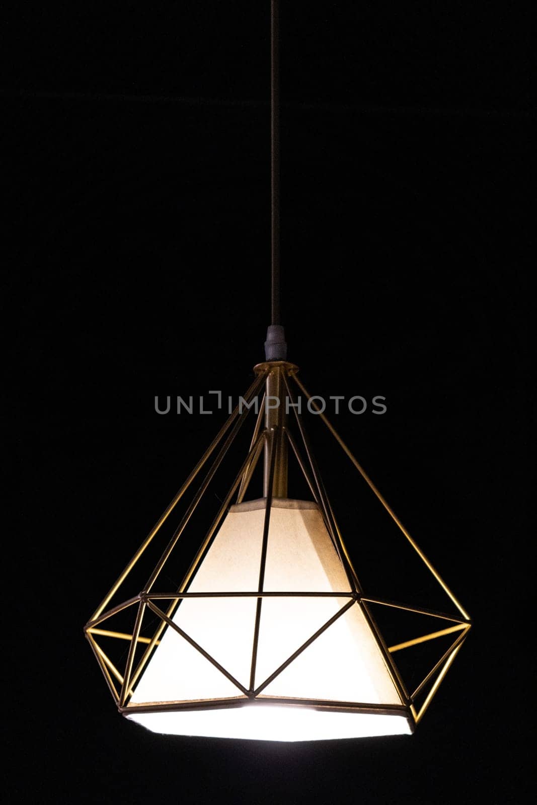 Close-up of modern garden pendant lamp hanging outdoor terrace during in the dark, vertical.