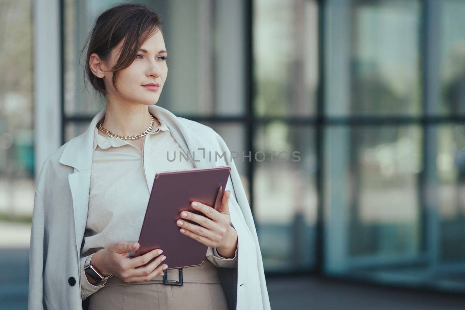 Business portrait of a young successful caucasian beautiful woman with a tablet in her hands. Copy space