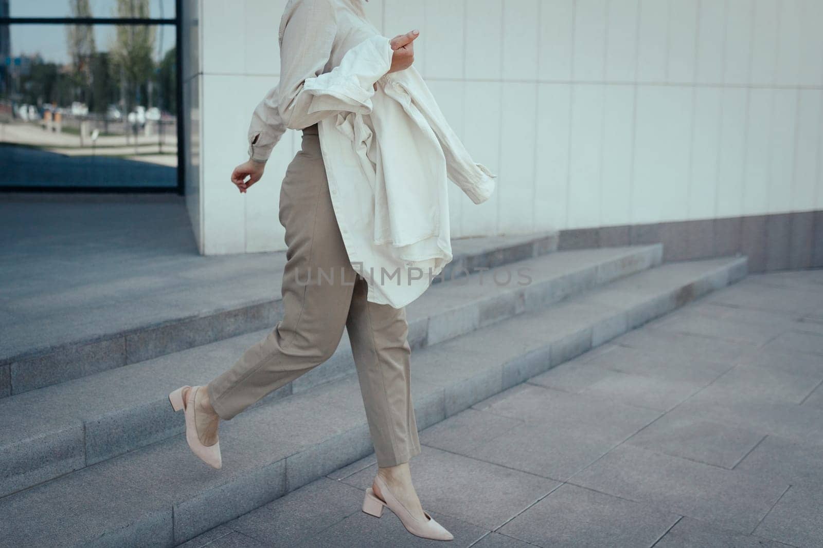 Business woman go down the stairs. Female legs in heels shoes walking on the stairway.